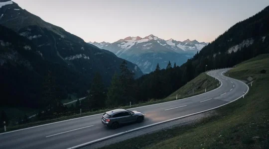 Une route de montagne suisse au crépuscule avec une voiture isolée, symbolisant la protection juridique circulation en complément de l'assurance RC Auto